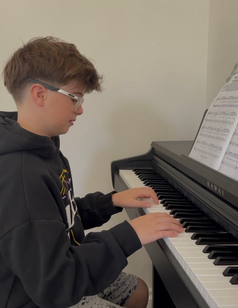 Teenage piano student with glasses